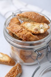 Photo of Traditional Italian almond biscuits (Cantucci) in jar on light table, closeup