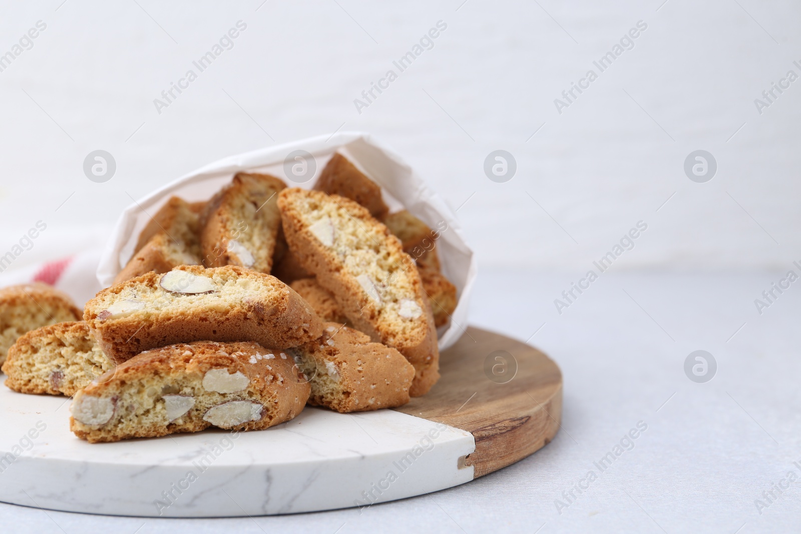 Photo of Traditional Italian almond biscuits (Cantucci) on light table, closeup. Space for text