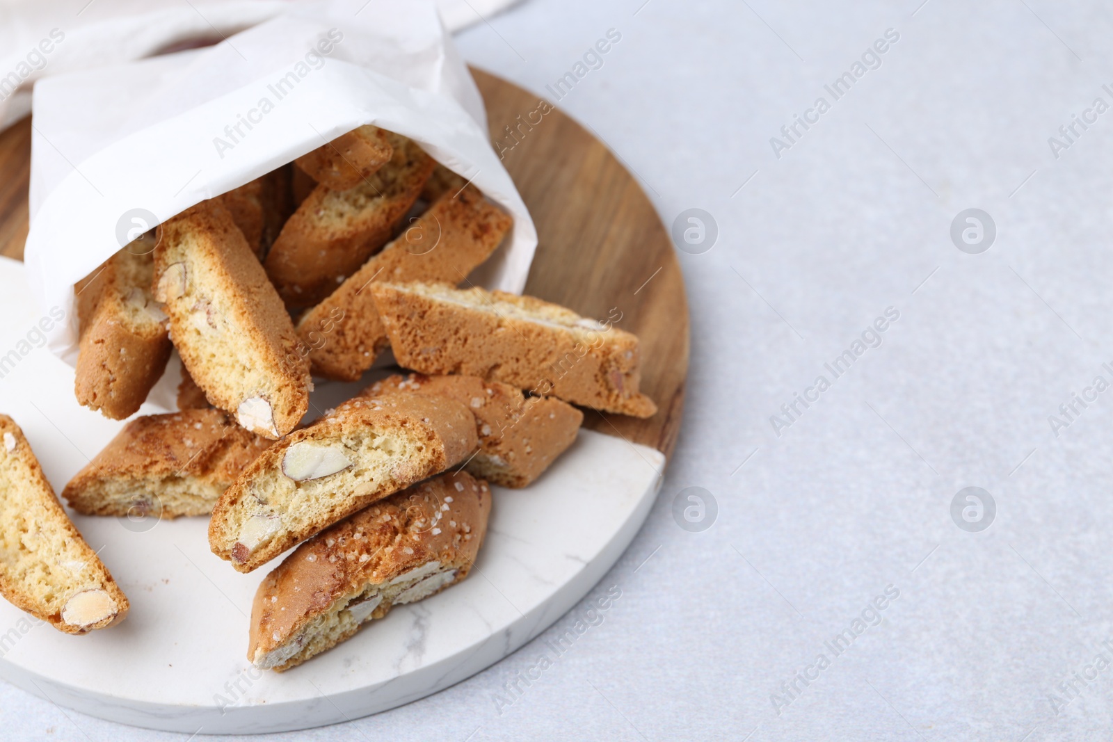 Photo of Traditional Italian almond biscuits (Cantucci) on light table, closeup. Space for text