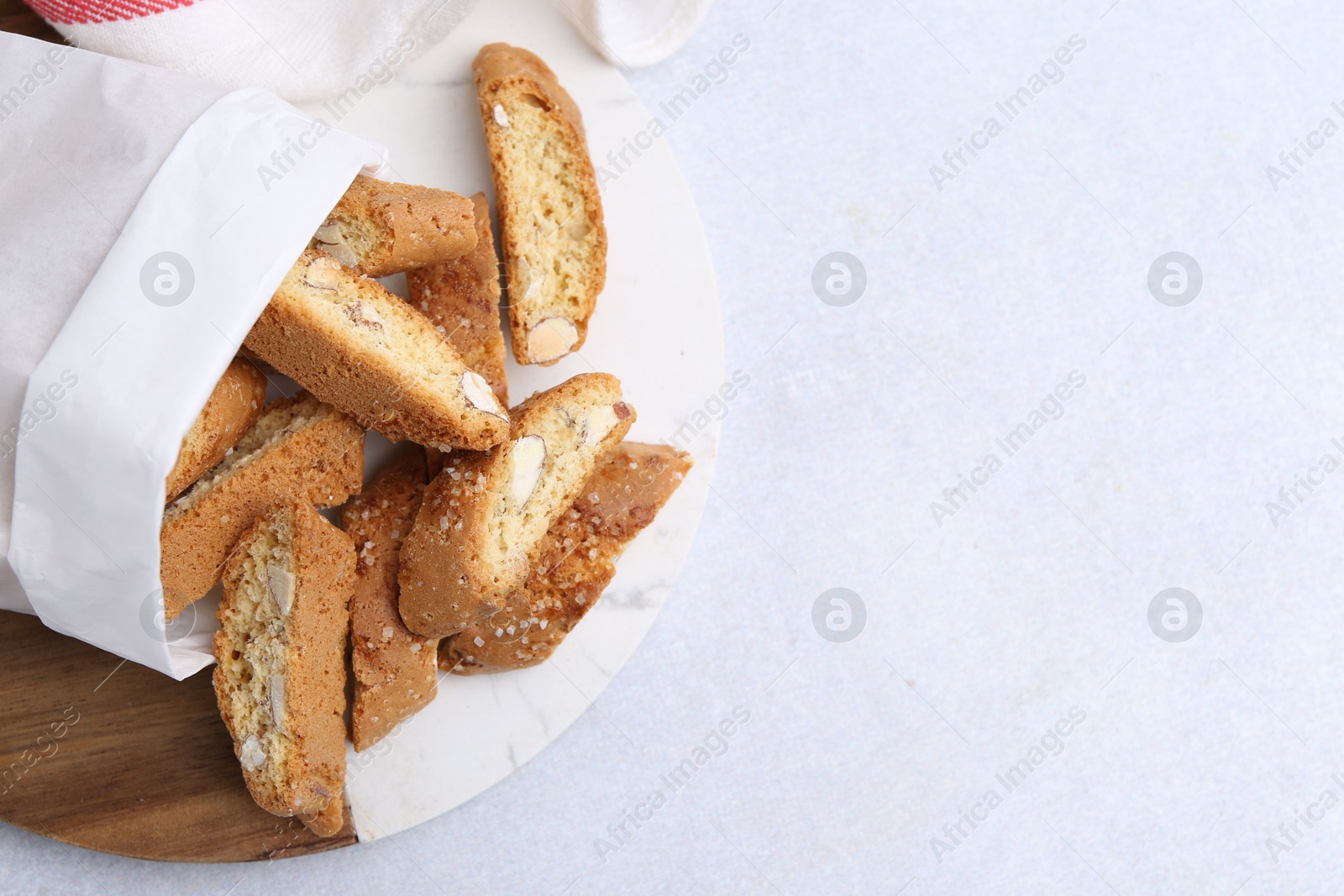 Photo of Traditional Italian almond biscuits (Cantucci) on light table, top view. Space for text