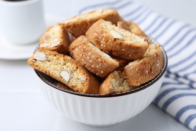 Photo of Traditional Italian almond biscuits (Cantucci) in bowl on white table, closeup