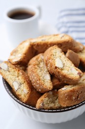 Photo of Traditional Italian almond biscuits (Cantucci) in bowl on white table, closeup