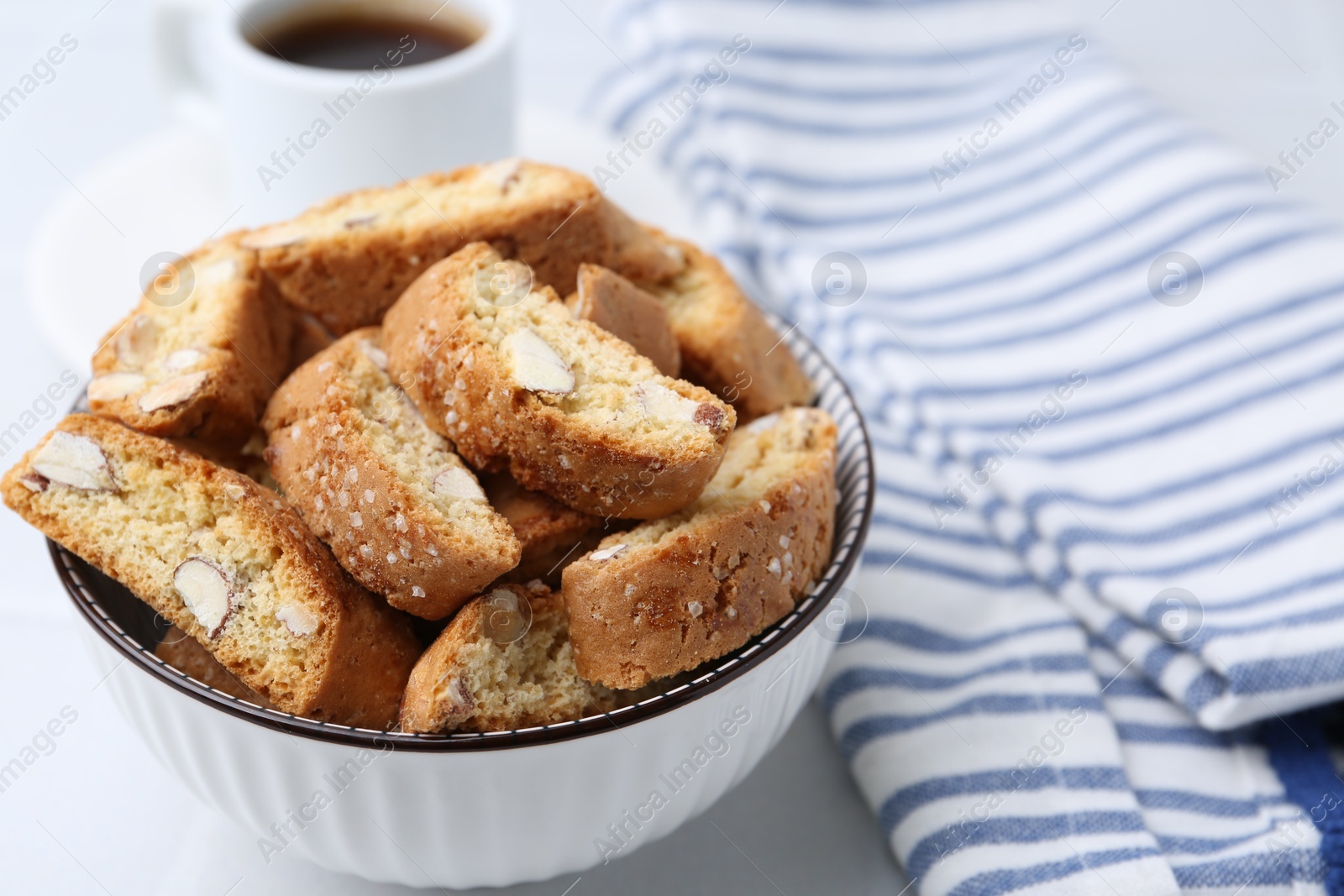 Photo of Traditional Italian almond biscuits (Cantucci) in bowl on white table, closeup