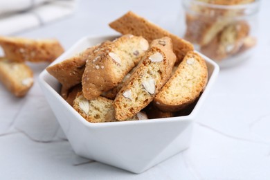 Photo of Traditional Italian almond biscuits (Cantucci) in bowl on white table, closeup