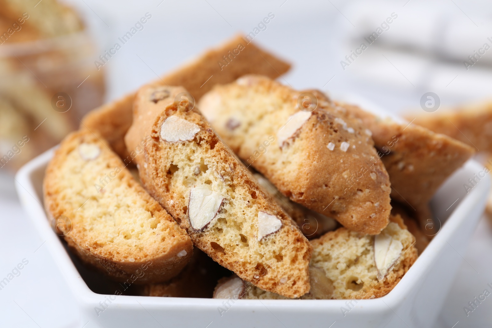 Photo of Traditional Italian almond biscuits (Cantucci) in bowl on table, closeup