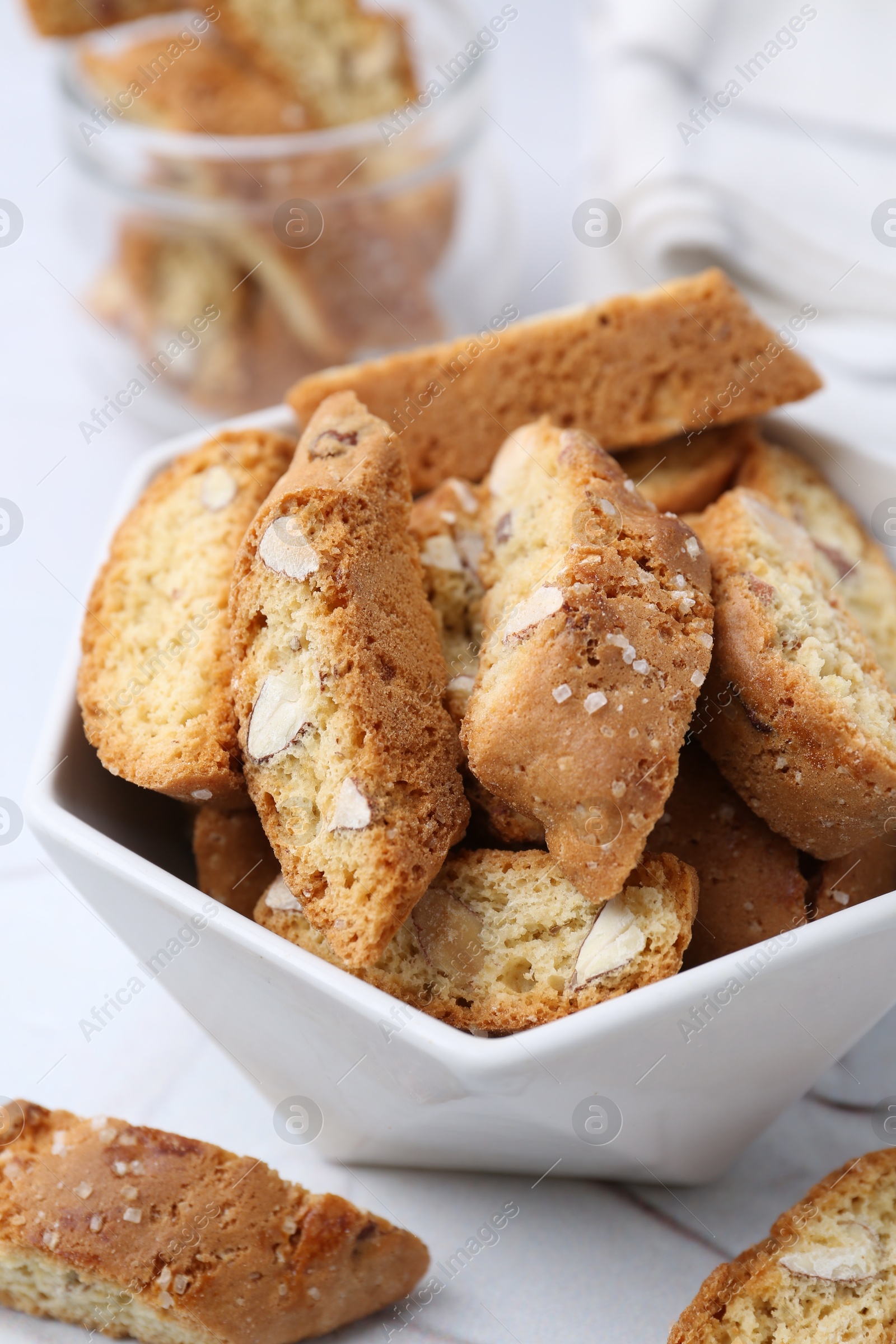 Photo of Traditional Italian almond biscuits (Cantucci) in bowl on table, closeup