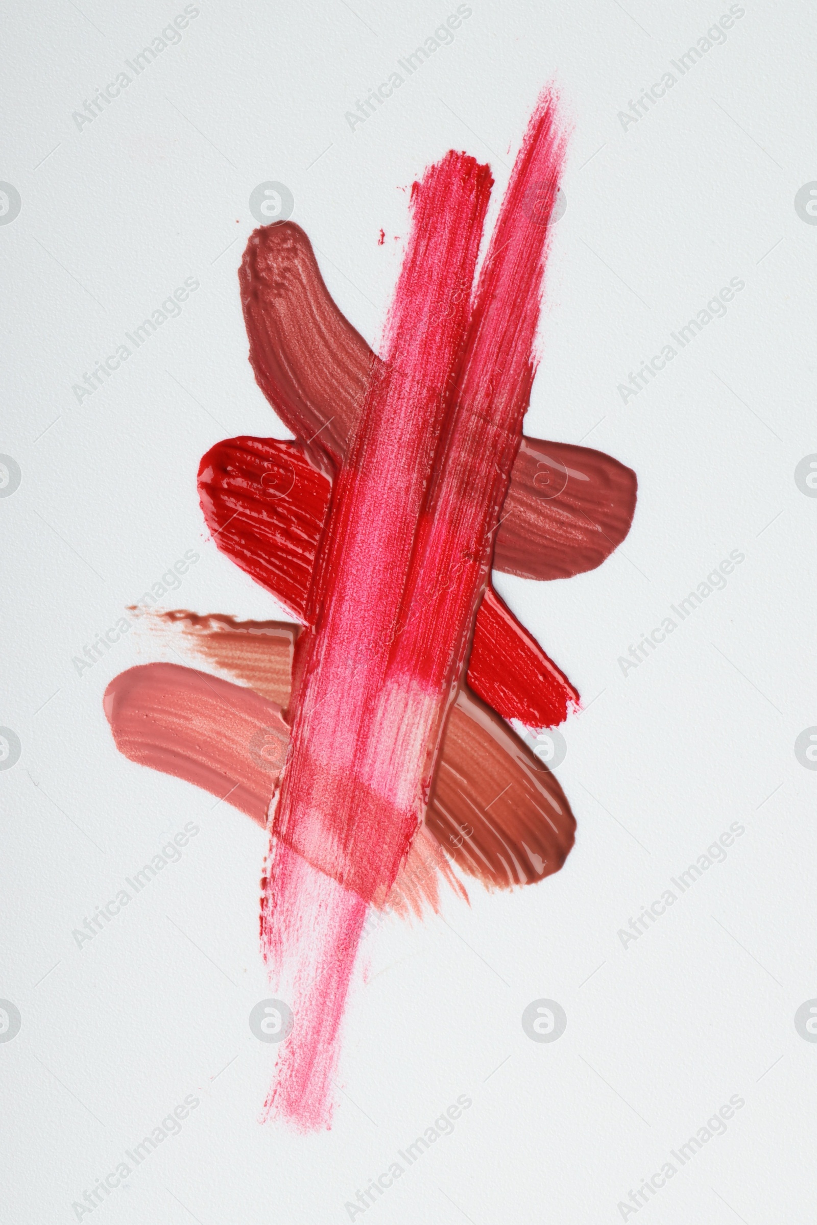 Photo of Different lipsticks isolated on white, top view. Samples of cosmetic product