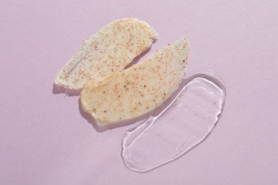 Photo of Samples of cosmetic products on light violet background, top view. Skin care