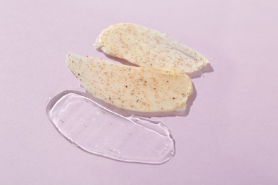 Photo of Samples of cosmetic products on light violet background, closeup. Skin care