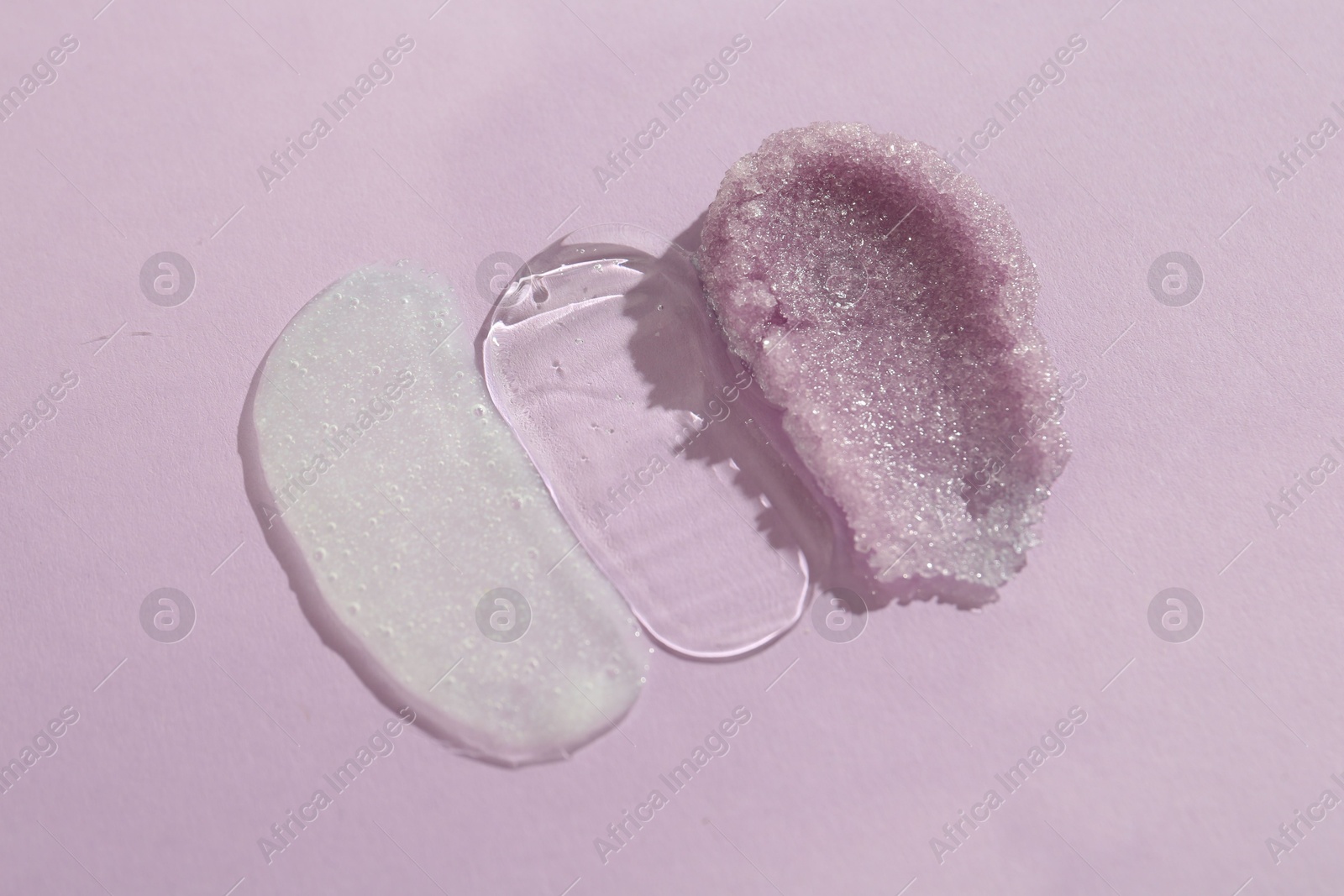 Photo of Samples of cosmetic products on light violet background, top view. Skin care