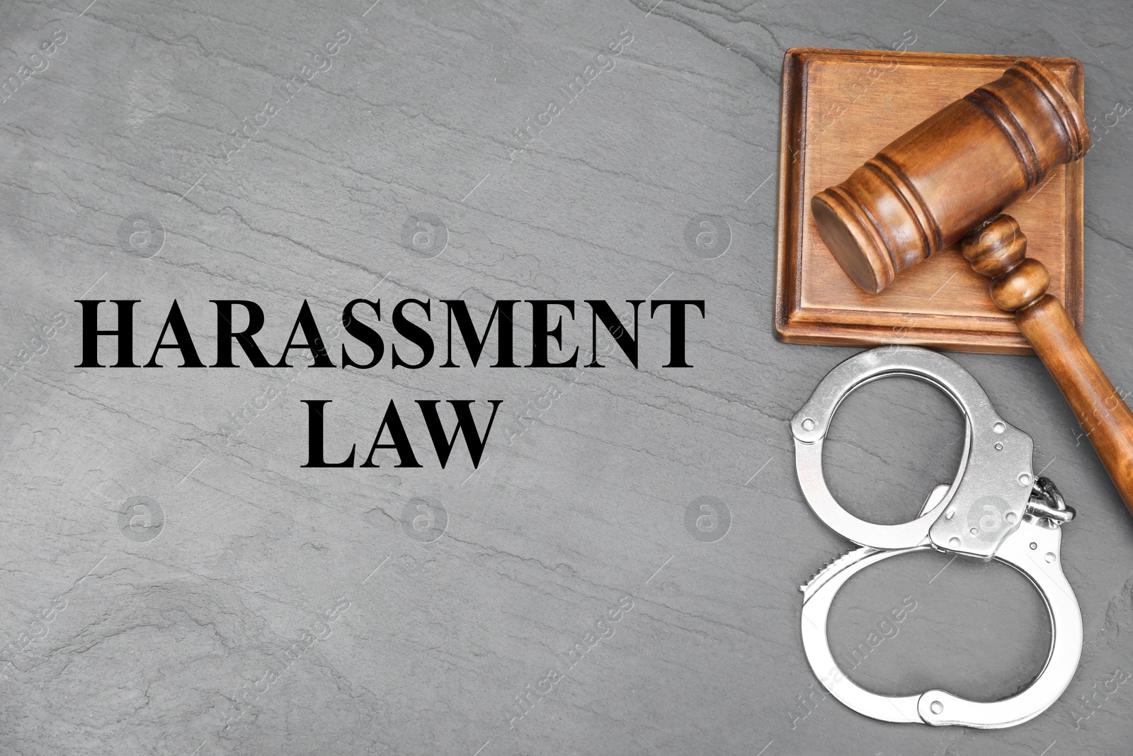 Image of Harassment law. Judge's gavel and handcuffs on gray textured table, flat lay