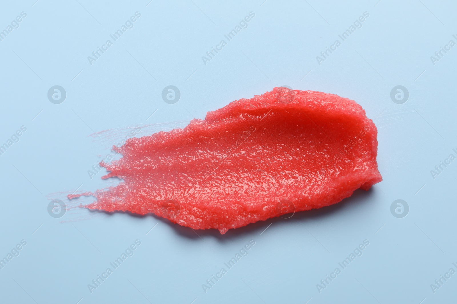 Photo of Smear of body scrub on light blue background, top view