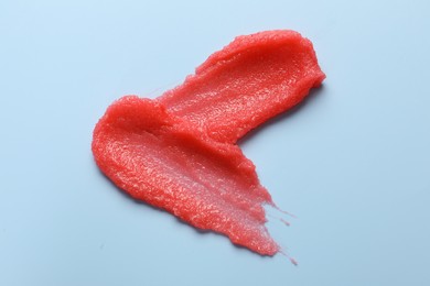 Photo of Smears of body scrub on light blue background, top view