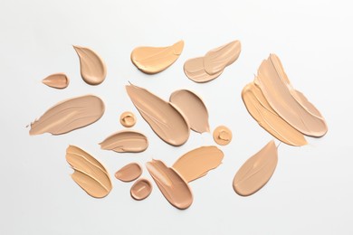 Photo of Samples of foundations on white background, top view