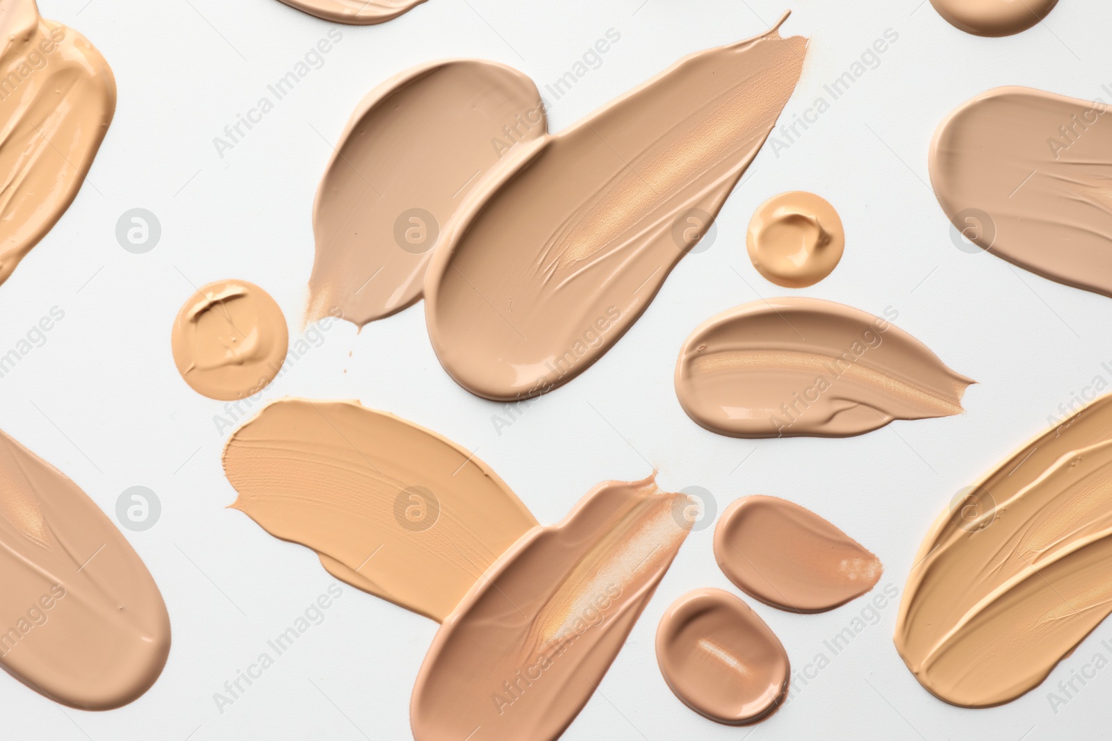 Photo of Samples of foundations on white background, top view