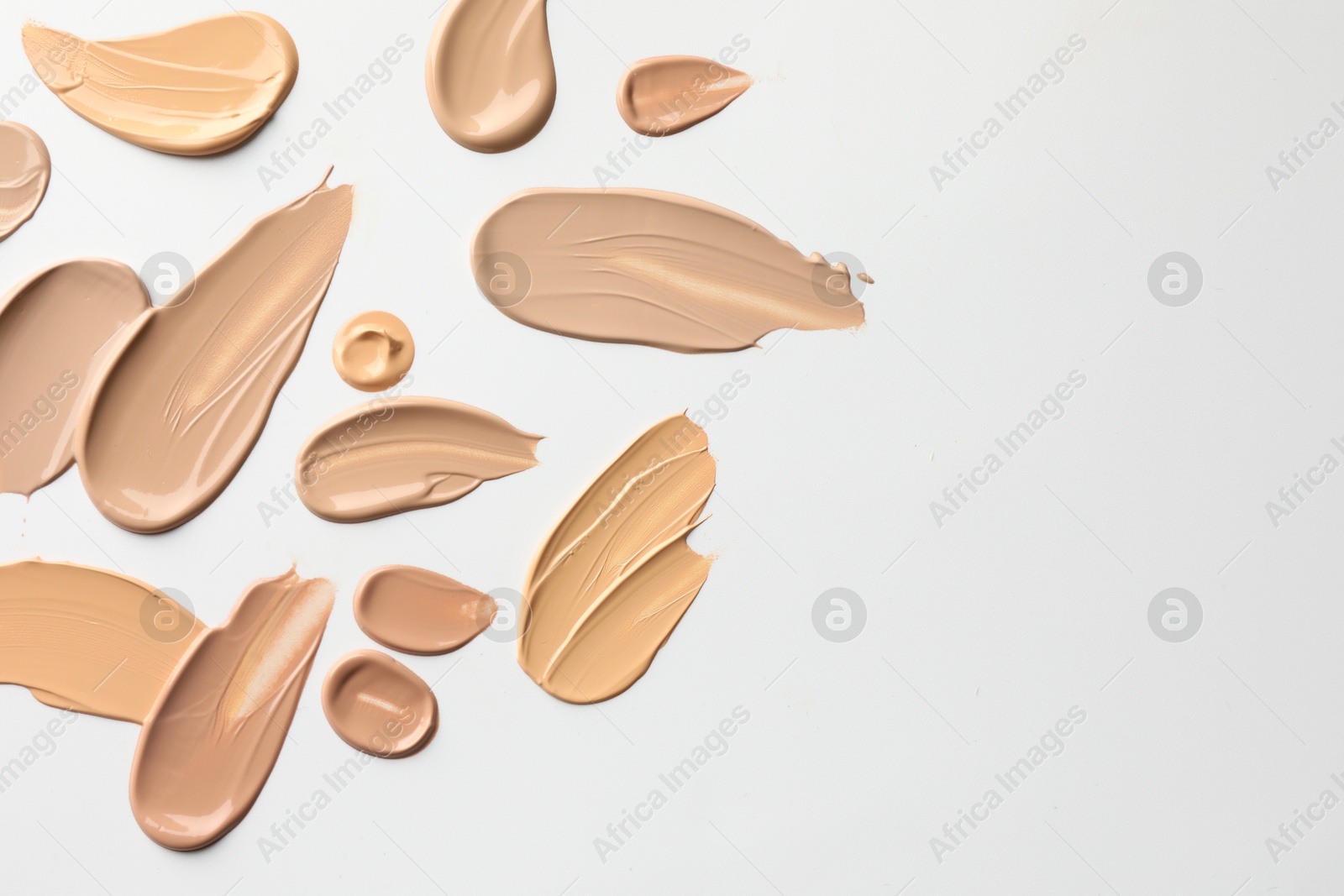 Photo of Samples of foundations on white background, top view