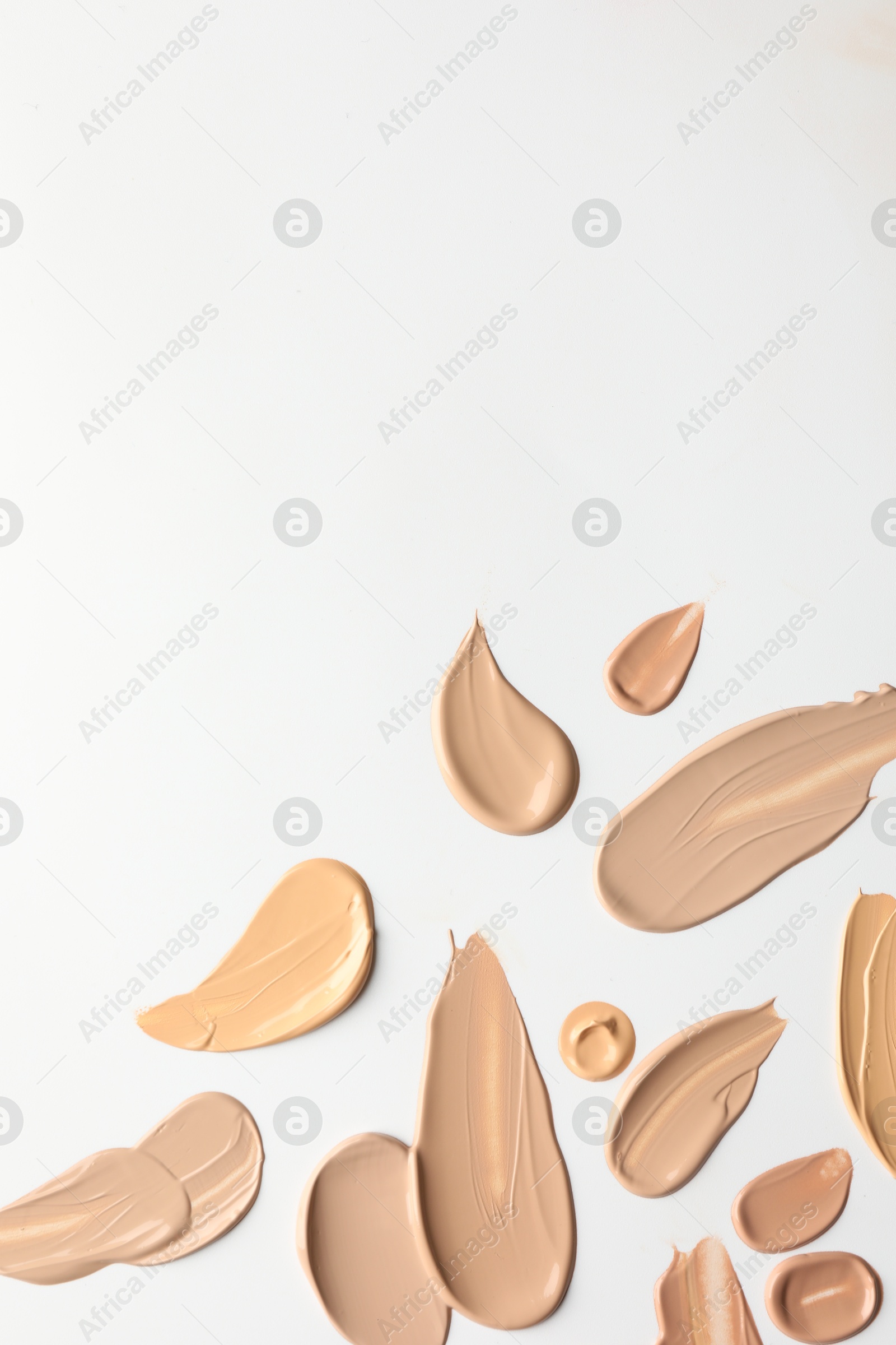 Photo of Samples of foundations on white background, top view