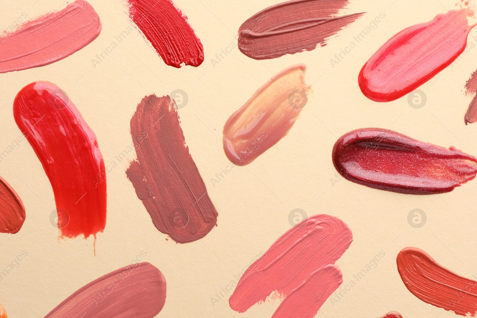 Photo of Samples of different lip products on beige background, top view