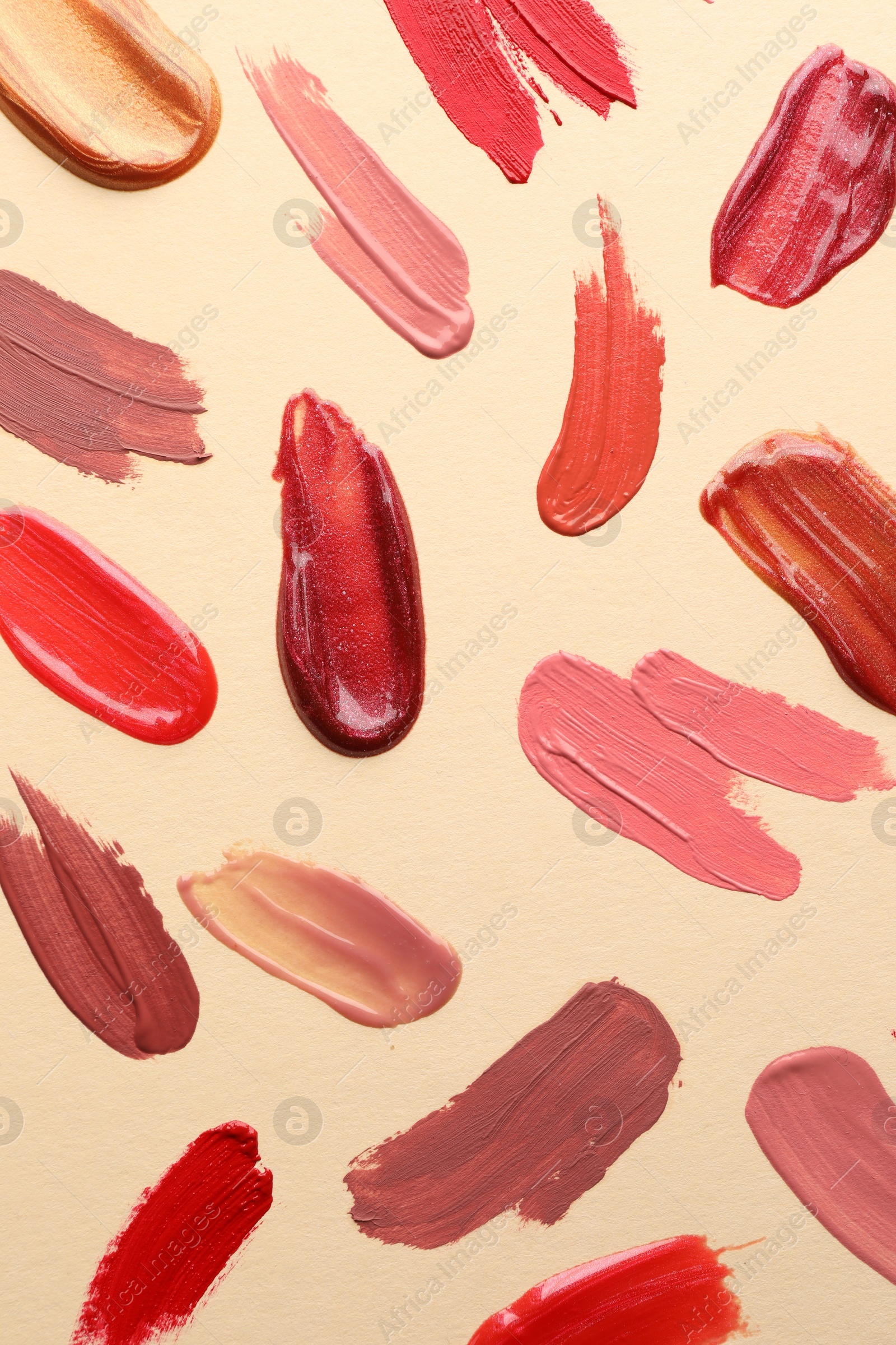 Photo of Samples of different lip products on beige background, top view