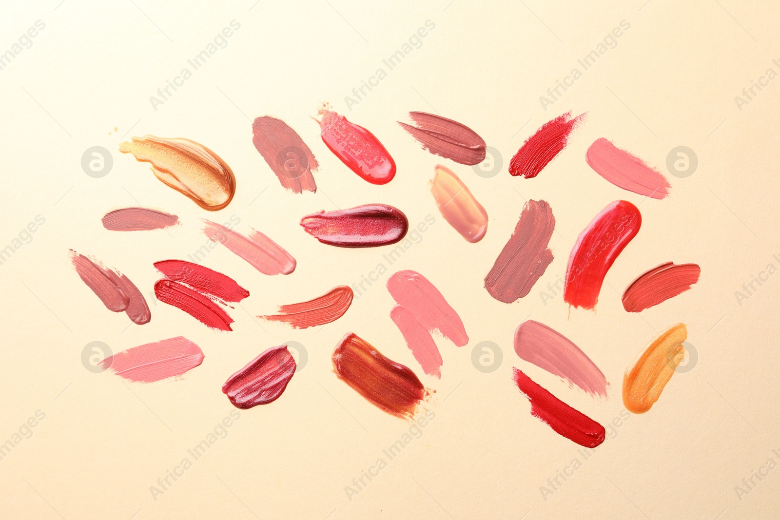 Photo of Samples of different lip products on beige background, top view