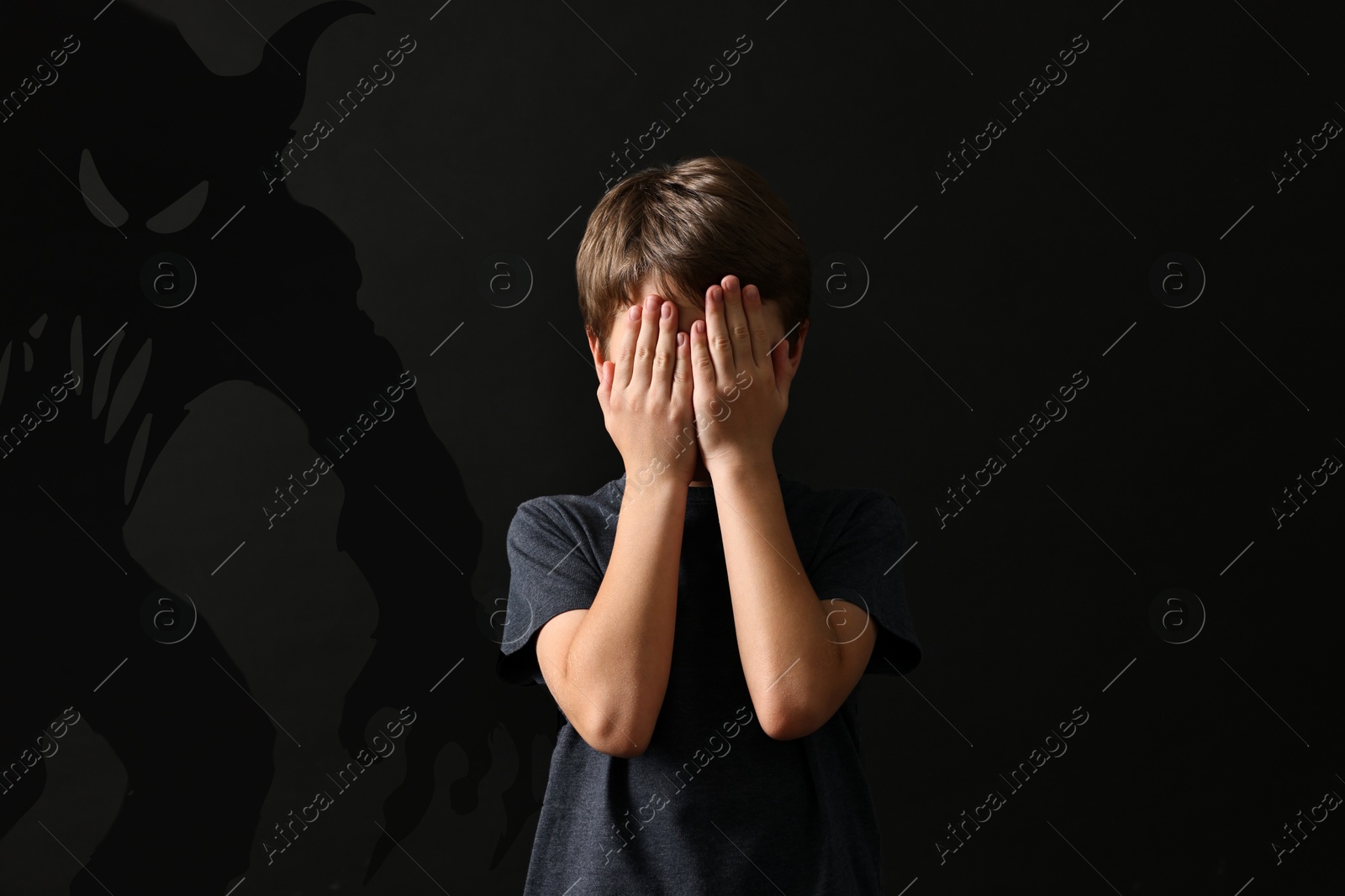 Illustration of Frightened by monsters, boy covering his eyes, teraphobia. Creepy shadows behind him