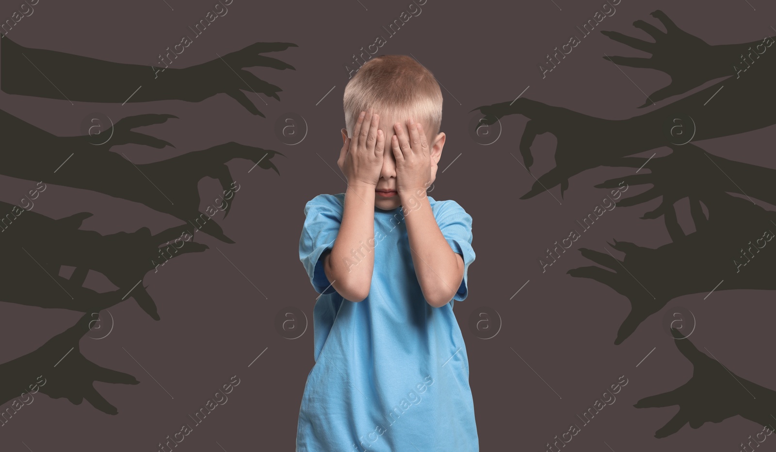 Image of Teraphobia - fear of monsters. Scared boy covering his eyes on dark background. Silhouette of creepy hands behind child