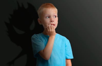 Illustration of Boy scared of monsters, teraphobia. Creepy shadow behind him