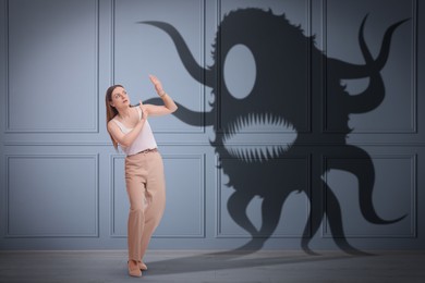 Image of Woman scared by monster. Creepy shadow in room