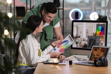 Photo of Professional retoucher with colleague at workplace in office