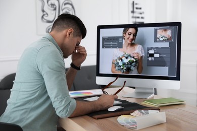 Photo of Tired retoucher at workplace with computer in office