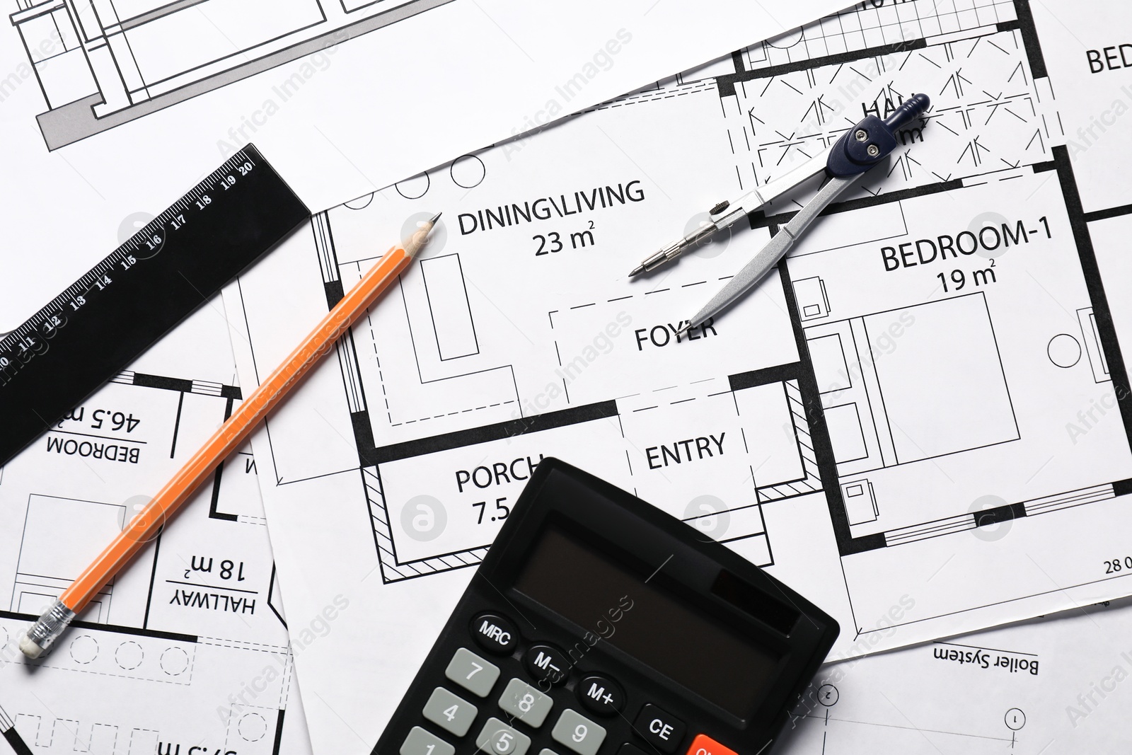 Photo of Pencil, dividers, calculator and ruler on different architectural drawings, top view