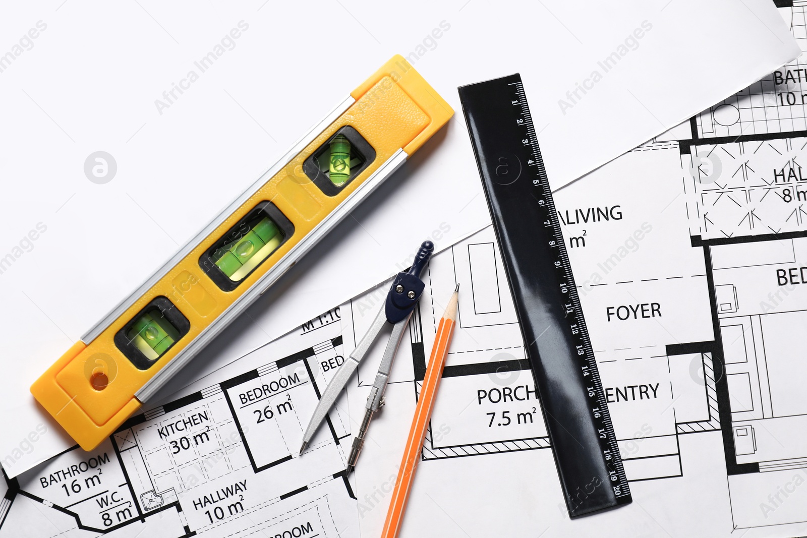 Photo of Pencil, dividers, building level and ruler on different architectural drawings, top view