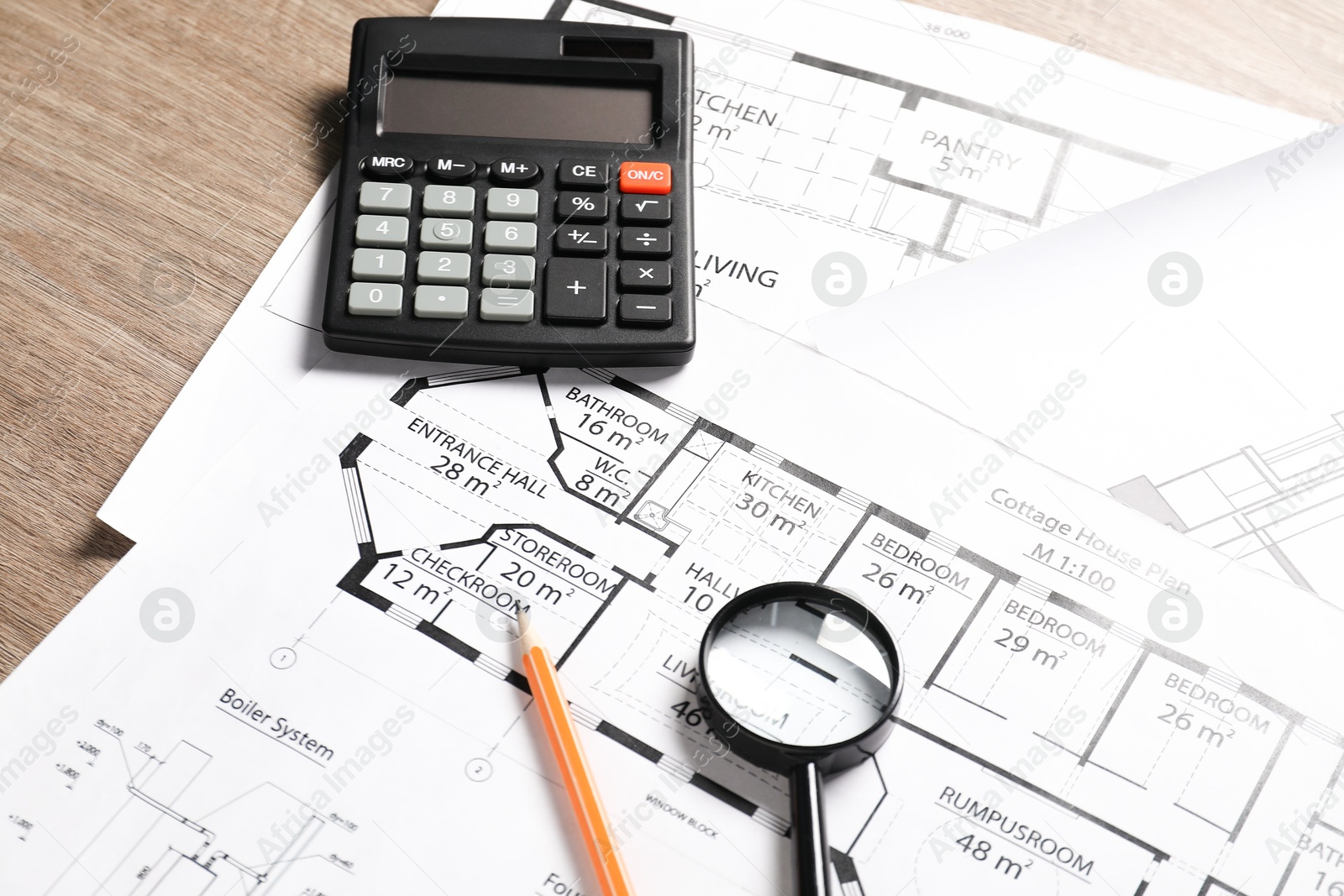 Photo of Different engineering drawings, pencil, calculator and magnifying glass on wooden table