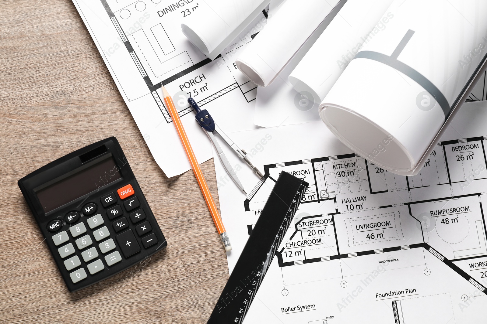 Photo of Different engineering drawings, ruler, pencil, calculator and dividers on wooden table, flat lay