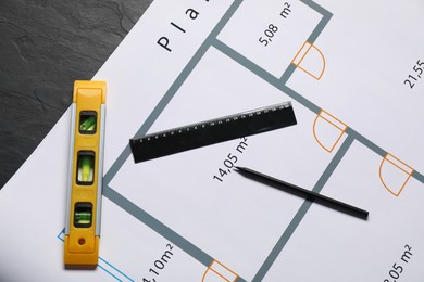 Architectural drawing, building level, ruler and pencil on grey textured table, flat lay