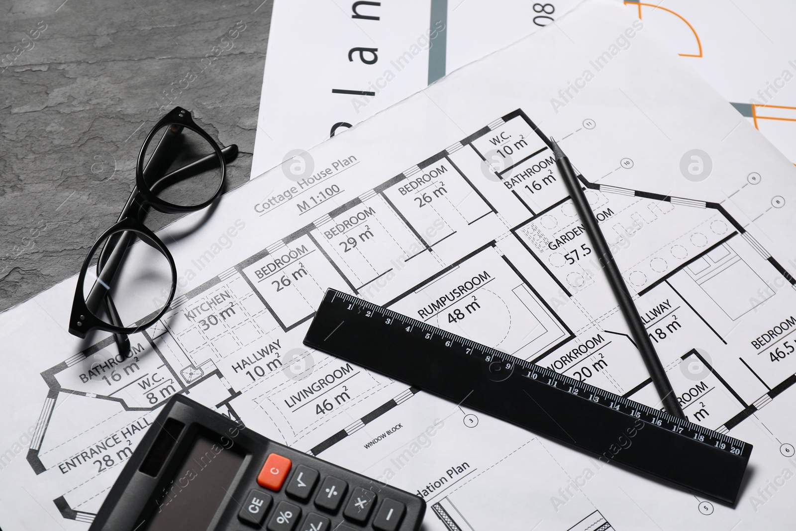 Photo of Different architectural drawings, glasses, calculator and ruler on grey textured table, flat lay