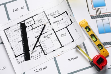 Photo of Different tools on architectural drawings, flat lay