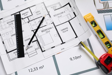 Different tools on architectural drawings, flat lay