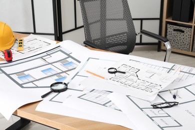 Photo of Different engineering drawings and tools on wooden table in architect`s office