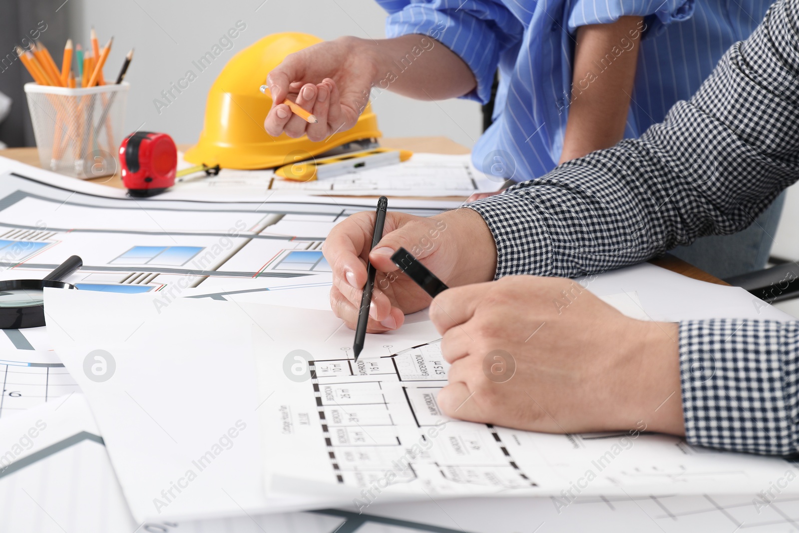 Photo of Architects working with project at table in office, closeup