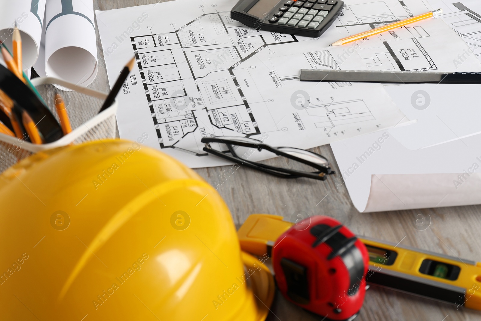 Photo of Different engineering drawings and tools on wooden table, closeup