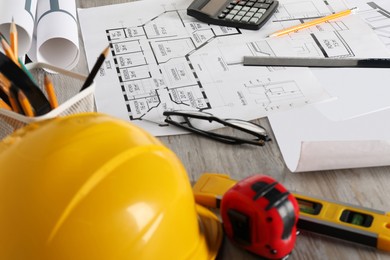 Photo of Different engineering drawings and tools on wooden table, closeup