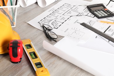 Photo of Different engineering drawings and tools on wooden table