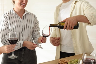 Photo of People with red wine and snacks indoors, closeup