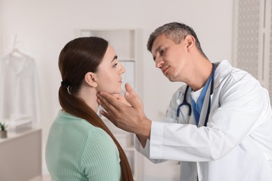 Photo of Doctor examining woman's throat in clinic during appointment