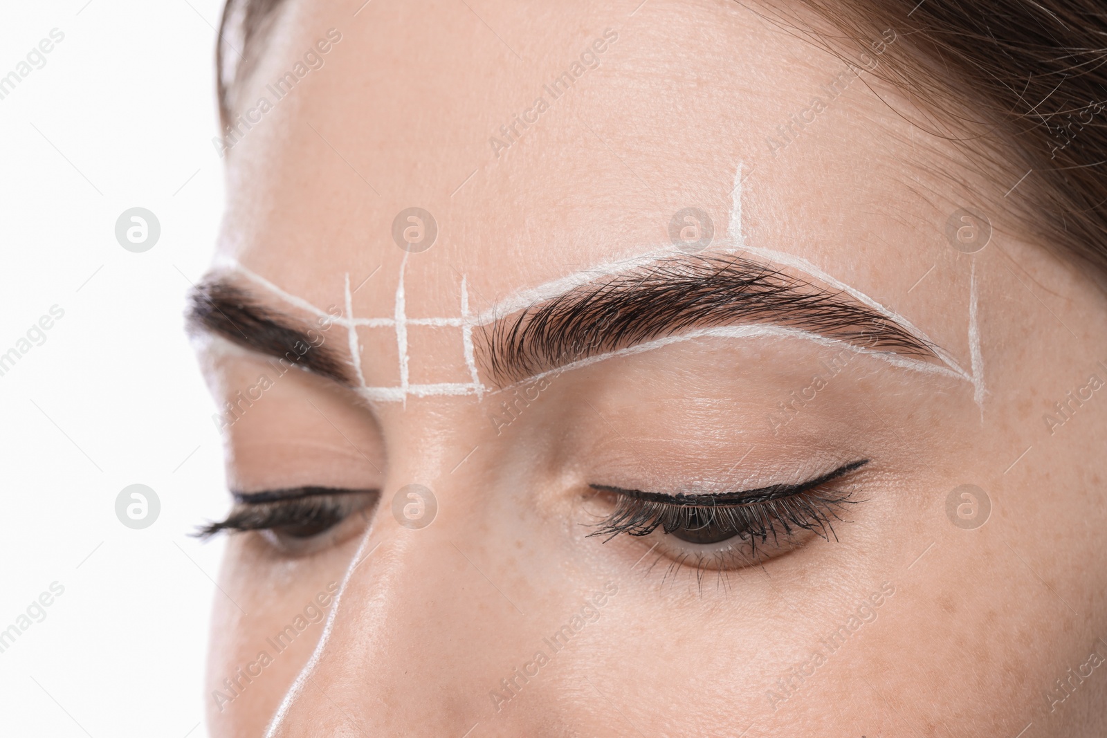 Photo of Young woman during henna eyebrows dyeing procedure on light background, closeup