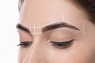 Photo of Young woman during henna eyebrows dyeing procedure on light background, closeup