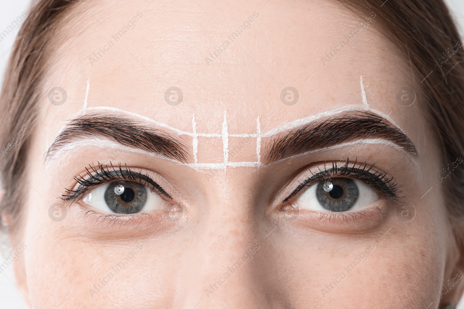 Photo of Young woman during henna eyebrows dyeing procedure on white background, closeup