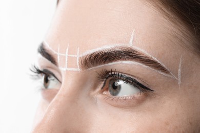 Photo of Young woman during henna eyebrows dyeing procedure on white background, closeup