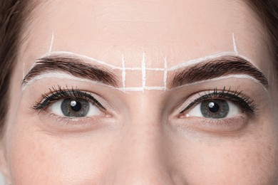 Photo of Young woman during henna eyebrows dyeing procedure, closeup